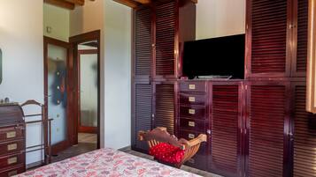 Une chambre à coucher avec un lit, une armoire et un téléviseur.
