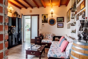A cozy room with a wooden coffee table, a sofa with a nautical theme, and a wall adorned with maritime artwork.