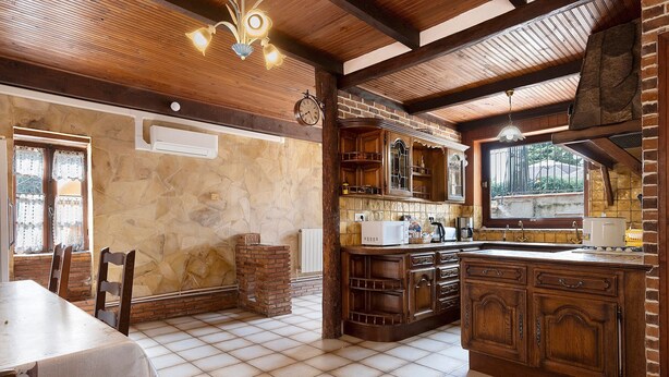 A rustic kitchen with exposed brick walls, wooden beams, and a tiled floor. - Holiday Home 'La Maison De Yana' with Private Pool, Shared Terrace and Wi-Fi (Saint-Marcel-d'Ardèche)