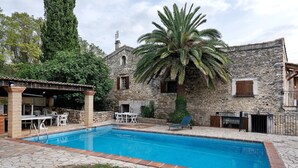 A stone building with a swimming pool, outdoor seating, and a palm tree. - Holiday Home 'La Maison De Yana' with Private Pool, Shared Terrace and Wi-Fi (Saint-Marcel-d'Ardèche)