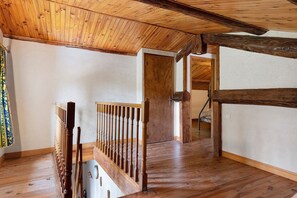 Eine Holztreppe mit Geländer führt zu einer Tür.