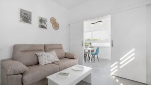 Una sala de estar moderna con sofá, una mesa de centro y un comedor con sillas y una mesa.