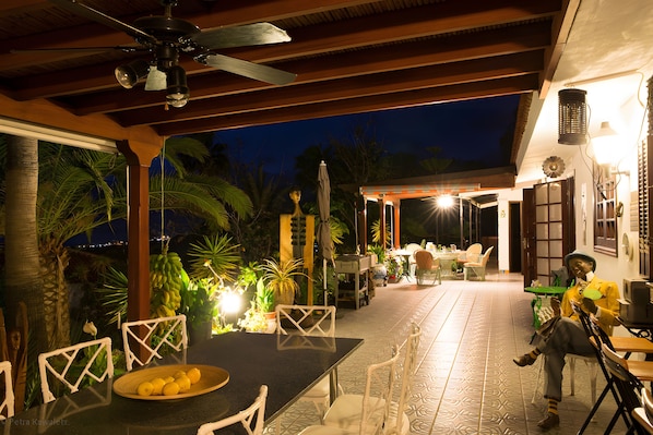 Un patio al aire libre con una mesa, sillas y una estatua decorativa.