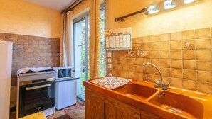 A kitchen with a sink, oven, and a calendar on the wall.