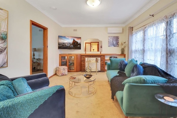 Stylish Art Deco living room with plush seating, natural light and classic coastal charm.