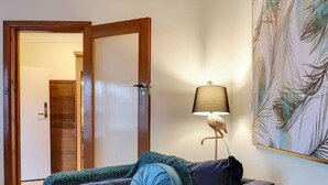 Ein Wohnzimmer mit Sofa, Lampe und einem Bild an der Wand.