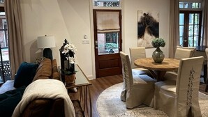 Un accogliente soggiorno con divano, tavolino e zona pranzo con sedie e tavolo.
