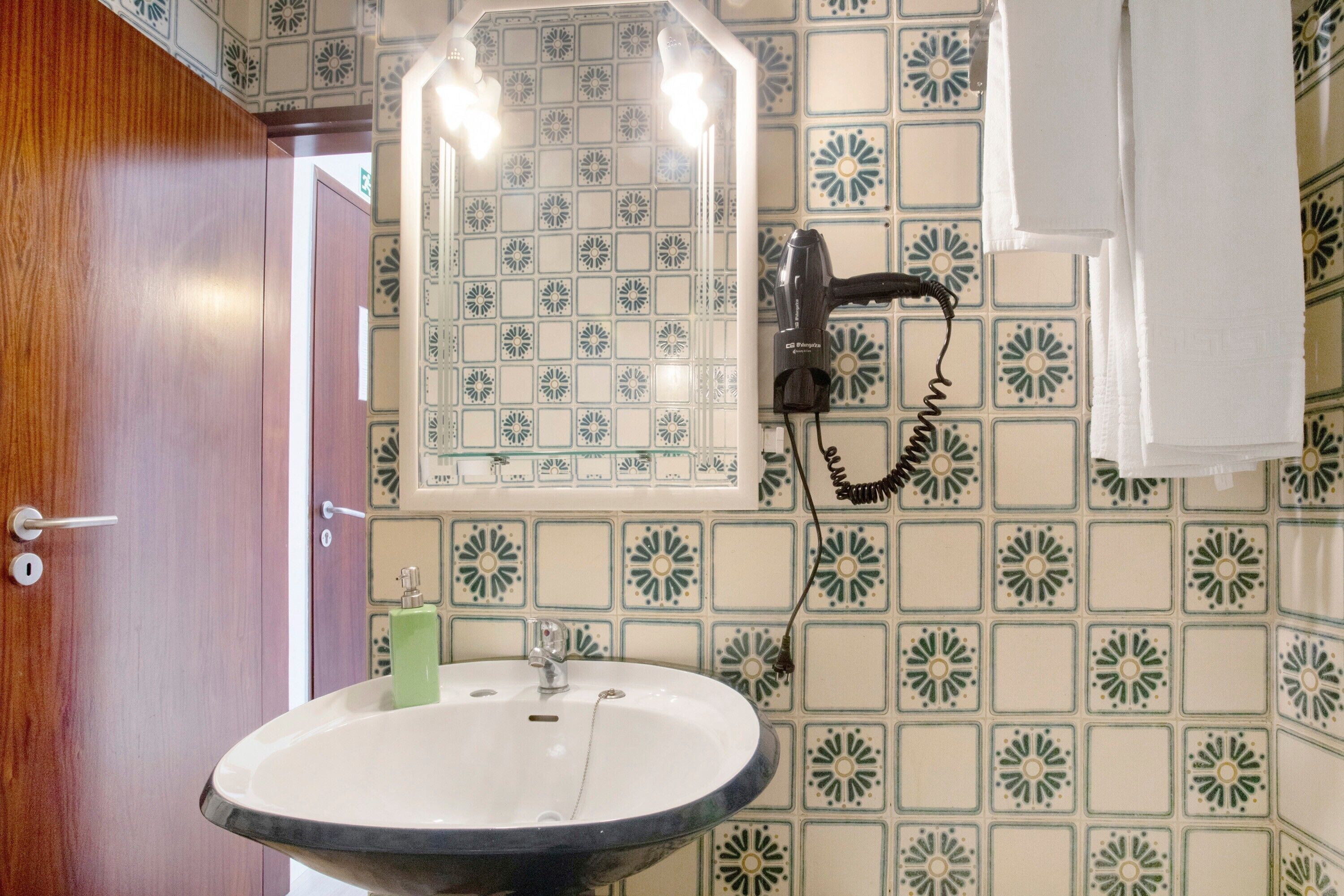 Une salle de bain équipée d’un lavabo, d’un miroir et d’un porte-serviettes.