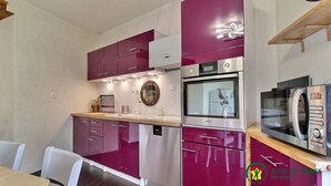 A compact kitchen with modern appliances, including a microwave, oven, and sink. - Maison de la Vilaine (SAINT DOLAY)
