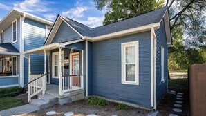 A two-story house with a front porch, a visible address number, and a well-maintained lawn. - Core's Cottage: Fountain Square- Cozy 1BR Dwtn Indy (Indianapolis)