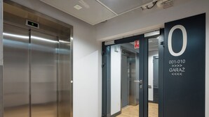 A modern elevator with a digital display, a glass door, and a floor number indicator. - Praga Bliska Glamour Studio (Warszawa)