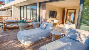 A modern outdoor living area with a sofa, chairs, and potted plants. - Stunning 4BR Luxury Retreat w Private Rooftop Pool (Playa Del Carmen)