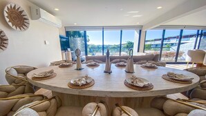 A round table with woven placemats and a central vase, surrounded by cushioned chairs. - Stunning 4BR Luxury Retreat w Private Rooftop Pool (Playa Del Carmen)