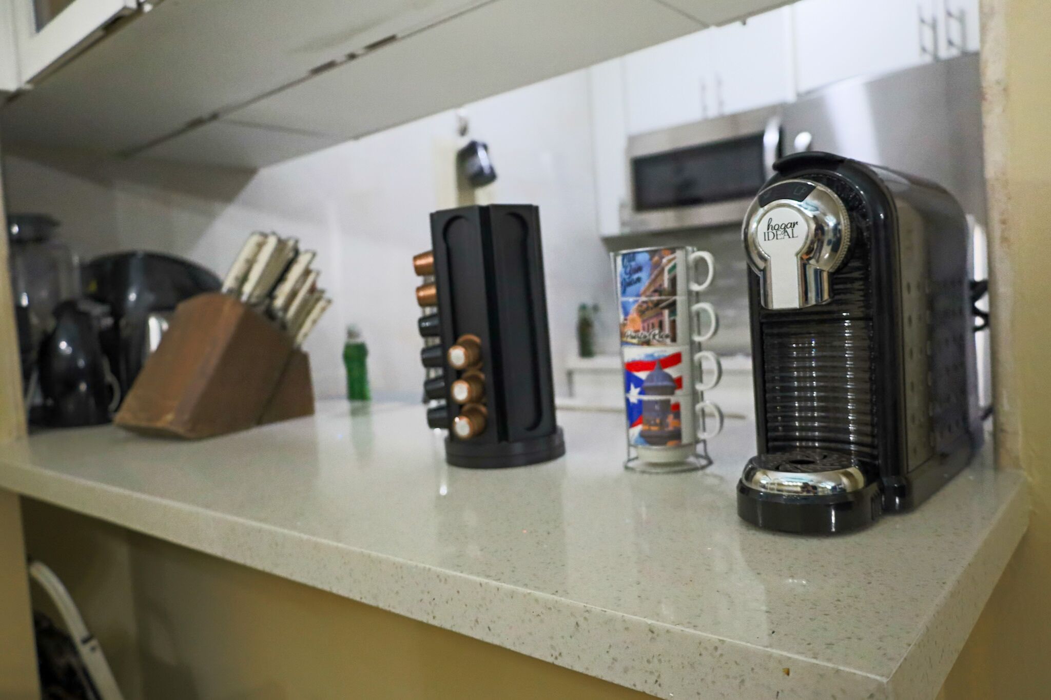 Un plan de travail de cuisine avec une machine à café, un grille-pain et une tasse.
