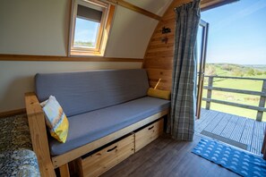 A cozy interior with a wooden bench, a window, and a view of the outdoors.