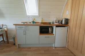 A compact kitchen with a microwave, sink, and a small refrigerator. - Luxury Cabin with Hot Tub in the Welsh Countryside (Knighton)