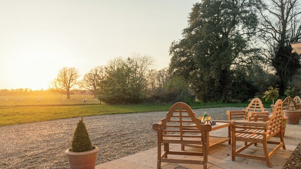 Une terrasse avec des meubles en bois et une plante en pot.
