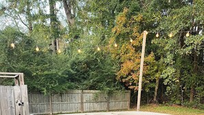 A hot tub with a wooden deck, a potted plant, and a wooden bench. - Near ILM Family Gathering Home, Sleeps up to 8, host up to 12. Your Holiday spot (Wilmington)