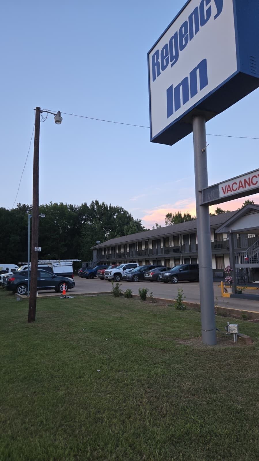 A Regency Inn sign, a parking lot with several cars, and a building with a 'VACANCY' sign.