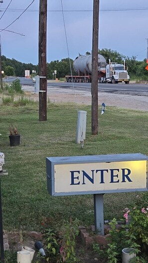 Een bord met de tekst 'ENTER' op een paal, omringd door gras en bloempotten.