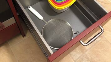 A drawer with a colorful container and a strainer.
