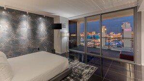 A modern hotel room with a large bed, a TV, and a city view. - Remodeled Strip View 1BD/1.5BA • Balcony • Sleeps 6 • No Resort Fee • Free Parking • QJ26 (Las Vegas)
