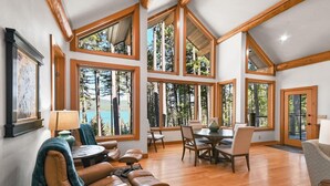 Un'ampia stanza con grandi finestre, un'area pranzo e un angolo relax.
