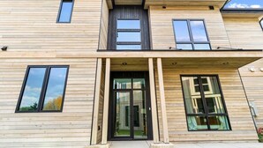 A modern two-story building with a wooden facade, large windows, and a central entrance with glass doors. - Whitefish Vista Retreat (Whitefish)