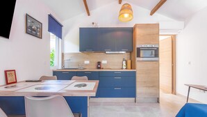 Eine moderne Küche mit dunkelblauen Schränken, einer Holzarbeitsplatte und einem eingebauten Backofen.
