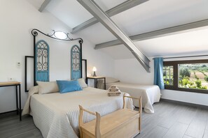 A bedroom with a bed, bedside tables, a wooden bench, and a view of the outdoors.
