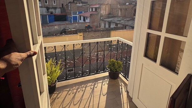 Een balkon met uitzicht op een stadsgezicht, met gebouwen en een heldere lucht.