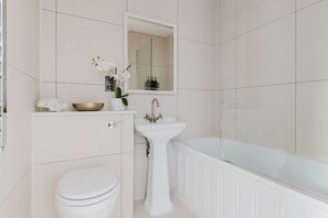 A bathroom with a toilet, sink, and bathtub. - Chic Fitzrovia 1BR, Furnished & Equipped, by Blueground (London)