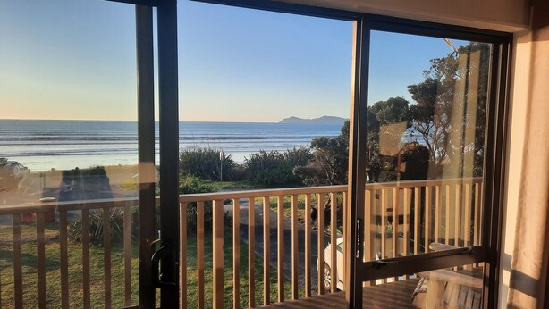 A balcony with a view of the ocean and distant mountains. - Sunset cottage Paekākāriki - sand, sea and sunsets (Paekakariki)
