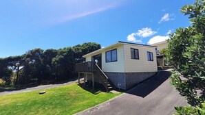 A single-story mobile home with a small deck and a ramp leading to the entrance. - Sunset cottage Paekākāriki - sand, sea and sunsets (Paekakariki)
