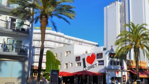 Un edificio con toldo rojo y un cartel que dice 'I ♥ LORET'.