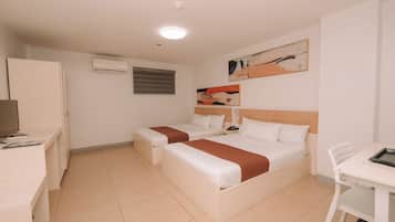 A hotel room with two beds, a desk, a chair, and a TV.
