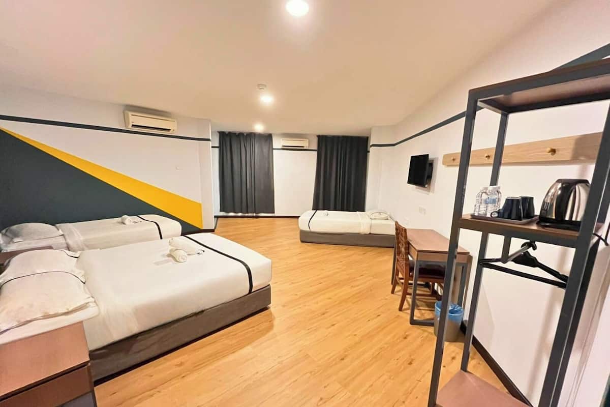 Une chambre d’hôtel avec deux lits, un bureau, une chaise, une télévision et une machine à café.