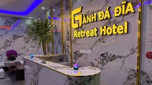 Una recepción con encimera de mármol y un letrero de neón para el Ganh Dao Retreat Hotel.