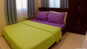 A bedroom with a bed, two pillows, a nightstand, and a wardrobe. - Entire home/Fully furnished/Netflix/AC/Wash/Dyer (Daet)