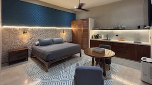 A modern bedroom with a bed, bedside tables, a ceiling fan, and a nightstand. - Casa Tunkul (Mérida)