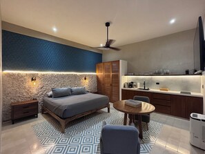 A modern bedroom with a bed, bedside tables, a ceiling fan, and a nightstand. - Casa Tunkul (Mérida)