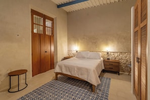Ein Schlafzimmer mit Bett, Nachttisch, Teppich und Muster.