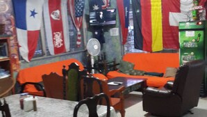 Un área de comedor con una mesa, sillas, un televisor y un ventilador.
