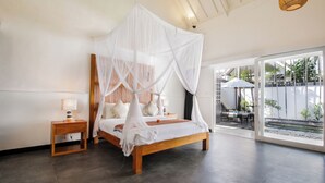 A bedroom with a wooden bed, white canopy, bedside tables, and a view of a pool and outdoor area. - Villa Zebra (Seminyak)