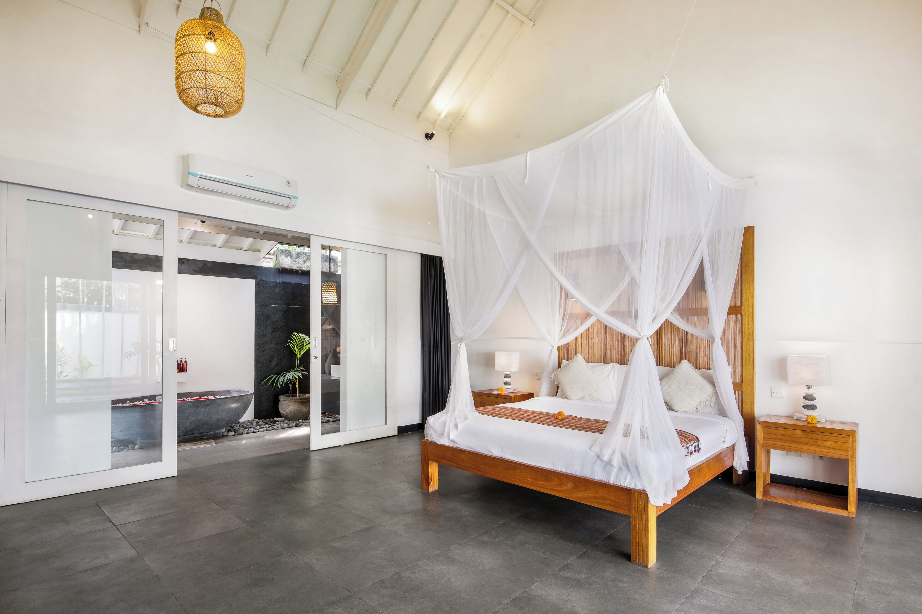 Une chambre à coucher moderne avec un lit en bois, un baldaquin blanc et une petite table de chevet.