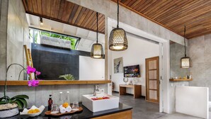A modern bathroom with a large mirror, wooden ceiling, and a black countertop. - Villa Zebra (Seminyak)
