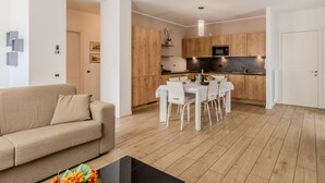 Een modern appartement met een zitkamer, eetgedeelte en keuken.