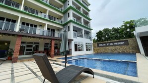 A multi-story hotel with a pool area, outdoor seating, and a sign reading "Dream Star Resort". - Dream'Star Resort Puerto Galera powered by Cocotel (Puerto Galera)