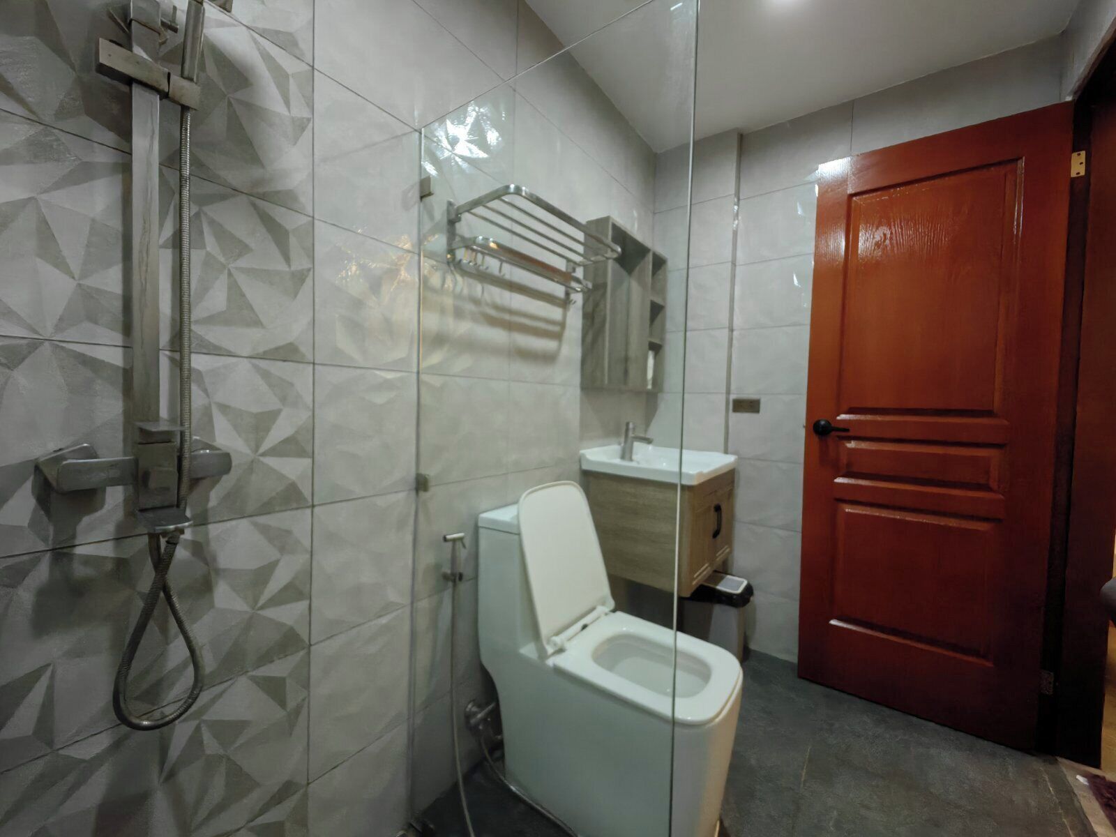 Une salle de bain avec des toilettes, un lavabo et une douche.