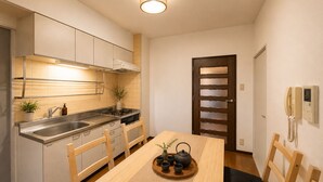 Una cocina compacta con comedor, estufa, pileta y teléfono.